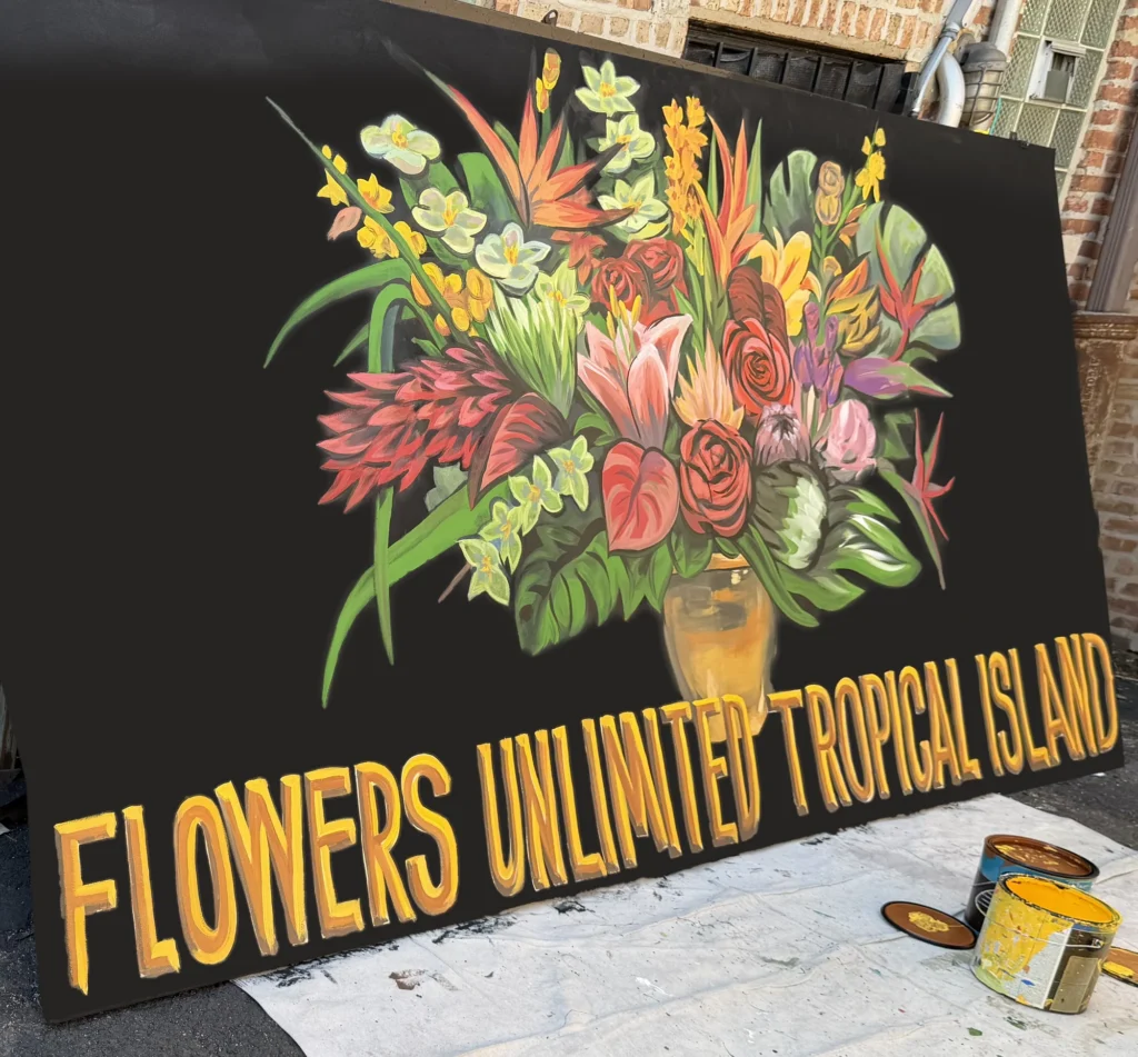 Flowers Unlimited Tropical Island, hand-painted sign by Caleb Wassell: a vase of tropical flowers with birds of paradise, roses, lilies and protea above gold lettering on a black board.